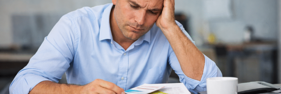 Frustrated Arkansas business owner reviewing paperwork and business cards while evaluating networking group ROI